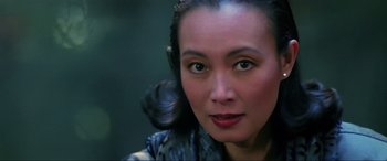 Movie still from “Crying Freeman” (1995), directed by Christophe Gans – A woman's face in a dark room; Close Up shot, Over the shoulder angle