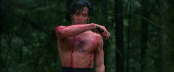 Movie still from “Crying Freeman” (1995), directed by Christophe Gans – A man with blood all over his body and chest; Medium shot, Low angle
