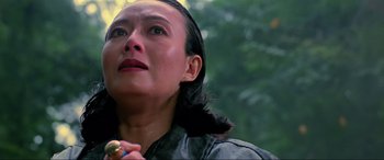 Movie still from “Crying Freeman” (1995), directed by Christophe Gans – A woman looking up into the sky while holding her hand up to her face; Close Up shot, Low angle