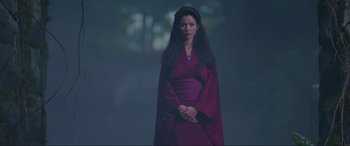 Movie still from “Crying Freeman” (1995), directed by Christophe Gans – A woman in a purple dress standing in the dark; Medium shot, Low angle