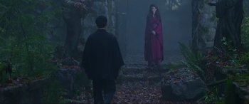 Movie still from “Crying Freeman” (1995), directed by Christophe Gans – A man and a woman dressed in medieval garb in the woods; Wide shot, Over the shoulder angle