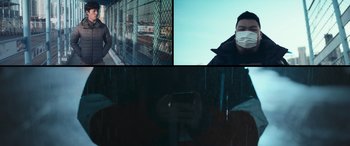 Movie still from “Cyber Hell: Exposing an Internet Horror” (2022), directed by Jin-sung Choi – A man wearing a face mask while holding a cell phone; Medium shot, Low angle