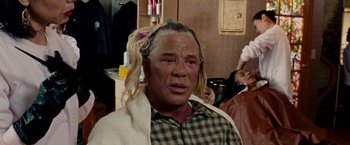 Movie still from “The Wrestler” (2008), directed by Darren Aronofsky – A man with long blonde hair is sitting in a room; Close Up shot, Over the shoulder angle