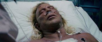 Movie still from “The Wrestler” (2008), directed by Darren Aronofsky – A man laying in a hospital bed with a bandage on his face; Close Up shot, Overhead angle