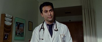 Movie still from “The Wrestler” (2008), directed by Darren Aronofsky – A male doctor wearing a lab coat and stethoscope; Close Up shot, Low angle