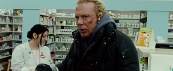 Movie still from “The Wrestler” (2008), directed by Darren Aronofsky – A man in a black jacket standing next to a store shelf; Close Up shot, Low angle