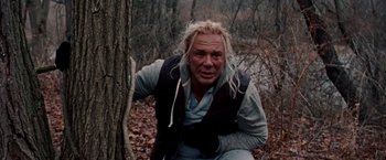 Movie still from “The Wrestler” (2008), directed by Darren Aronofsky – A man sitting on the ground next to a tree in the woods; Close Up shot, Low angle