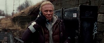 Movie still from “The Wrestler” (2008), directed by Darren Aronofsky – A man with blonde hair talking on a cell phone; Medium shot, Low angle