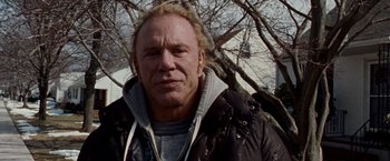 Movie still from “The Wrestler” (2008), directed by Darren Aronofsky – A person wearing a jacket near a tree; Close Up shot, Low angle