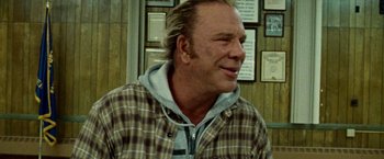Movie still from “The Wrestler” (2008), directed by Darren Aronofsky – A person wearing a plaid jacket; Close Up shot, Over the shoulder angle