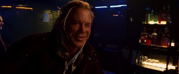 Movie still from “The Wrestler” (2008), directed by Darren Aronofsky – A man with headphones is smiling for the camera; Close Up shot, Over the shoulder angle