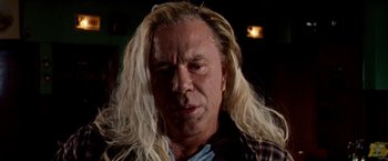 Movie still from “The Wrestler” (2008), directed by Darren Aronofsky – A man with long blonde hair and a plaid shirt; Close Up shot, Low angle