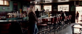 Movie still from “The Wrestler” (2008), directed by Darren Aronofsky – A man standing in front of a bar with two other people; Wide shot, Over the shoulder angle