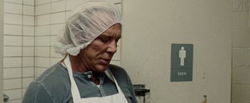 Movie still from “The Wrestler” (2008), directed by Darren Aronofsky – An older man wearing an apron and head covering; Close Up shot, Low angle