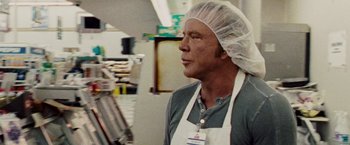 Movie still from “The Wrestler” (2008), directed by Darren Aronofsky – A man wearing a head covering in a store; Close Up shot, Over the shoulder angle