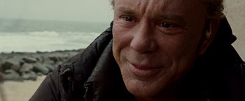 Movie still from “The Wrestler” (2008), directed by Darren Aronofsky – An older man wearing a black jacket looking at the camera; Close Up shot, Over the shoulder angle
