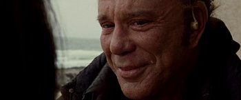 Movie still from “The Wrestler” (2008), directed by Darren Aronofsky – An older man with a smile on his face; Extreme Close Up shot, Over the shoulder angle