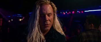 Movie still from “The Wrestler” (2008), directed by Darren Aronofsky – A man with long blonde hair is looking down; Close Up shot, Low angle