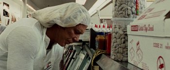 Movie still from “The Wrestler” (2008), directed by Darren Aronofsky – A man wearing a head covering looking down at a shelf; Close Up shot, Low angle