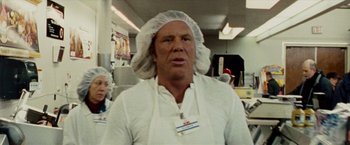 Movie still from “The Wrestler” (2008), directed by Darren Aronofsky – A man wearing a white apron and a white hat; Close Up shot, Over the shoulder angle