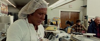Movie still from “The Wrestler” (2008), directed by Darren Aronofsky – A man wearing a white lab coat and a white hat; Close Up shot, Over the shoulder angle