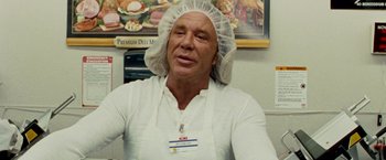 Movie still from “The Wrestler” (2008), directed by Darren Aronofsky – A man wearing a white apron and a white hat; Close Up shot, Low angle