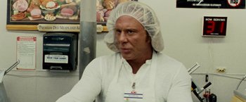 Movie still from “The Wrestler” (2008), directed by Darren Aronofsky – A man wearing a white apron and a white hat; Close Up shot, Over the shoulder angle