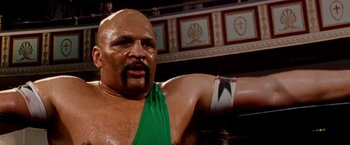 Movie still from “The Wrestler” (2008), directed by Darren Aronofsky – A man with a green shirt and a green arm band; Close Up shot, Low angle