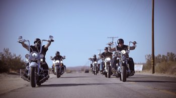 A group of men riding motorcycles down a street