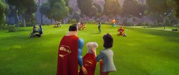Movie still from “DC League of Super-Pets” (2022), directed by Jared Stern – A group of people standing on top of a lush green field; Extreme Wide shot, Over the shoulder angle