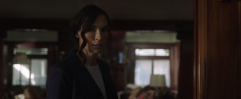 Movie still from “Dangerous” (2021), directed by David Hackl – A woman standing in front of a window in a living room; Close Up shot, Over the shoulder angle