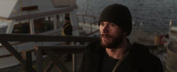 Movie still from “Dangerous” (2021), directed by David Hackl – A man with a beard wearing a black hat; Close Up shot, Over the shoulder angle