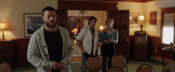 Movie still from “Dangerous” (2021), directed by David Hackl – A group of people standing in a living room; Medium shot, Over the shoulder angle