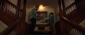 Movie still from “Dangerous” (2021), directed by David Hackl – A man and a boy are looking at a painting; Medium shot, Low angle