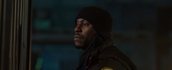 Movie still from “Dangerous” (2021), directed by David Hackl – A man in a black jacket wearing a black hat; Close Up shot, Low angle