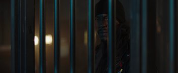 Movie still from “Dangerous” (2021), directed by David Hackl – A man standing behind bars in a jail cell; Close Up shot, Low angle