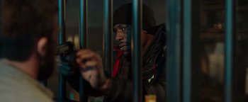 Movie still from “Dangerous” (2021), directed by David Hackl – A man looking through bars of a jail cell; Medium shot, Low angle