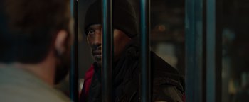 Movie still from “Dangerous” (2021), directed by David Hackl – A man in a black jacket behind bars; Close Up shot, High angle