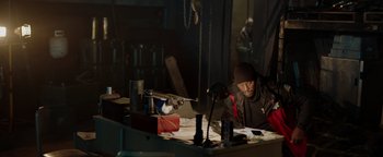 Movie still from “Dangerous” (2021), directed by David Hackl – A man sitting at a table in front of papers; Medium shot, High angle