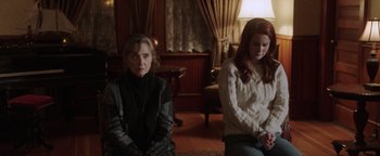 Movie still from “Dangerous” (2021), directed by David Hackl – Two women sitting in a living room next to each other; Medium shot, Over the shoulder angle