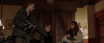 Movie still from “Dangerous” (2021), directed by David Hackl – A group of people standing in a living room; Medium shot, Over the shoulder angle
