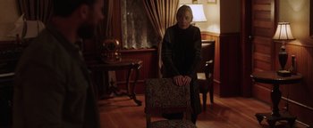 Movie still from “Dangerous” (2021), directed by David Hackl – A woman sitting on a chair in a living room; Medium shot, Over the shoulder angle