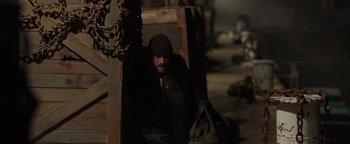 Movie still from “Dangerous” (2021), directed by David Hackl – A man sitting on the ground in a dark place; Wide shot, High angle