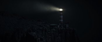 Movie still from “Dangerous” (2021), directed by David Hackl – A light shining on the top of a light house at night; Extreme Wide shot, Low angle