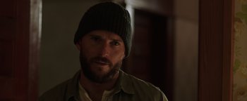 Movie still from “Dangerous” (2021), directed by David Hackl – A man with a beard wearing a hat and a shirt; Close Up shot, Over the shoulder angle