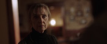 Movie still from “Dangerous” (2021), directed by David Hackl – An older woman is looking at the camera; Close Up shot, Over the shoulder angle