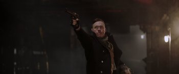 Movie still from “Dangerous” (2021), directed by David Hackl – A man holding a gun up in the air; Medium shot, Low angle