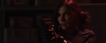 Movie still from “Dangerous” (2021), directed by David Hackl – A woman holding a gun in a dimly - lit room; Close Up shot, Over the shoulder angle