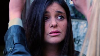 Movie still from “Dark Light” (2021), directed by Damian Chapa – A person with long black hair; Close Up shot, Over the shoulder angle