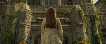Movie still from “Dark Phoenix” (2019), directed by Simon Kinberg – A woman with long brown hair standing in front of a building; Wide shot, Low angle
